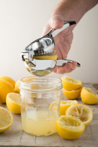 squeezing lemon into a glass
